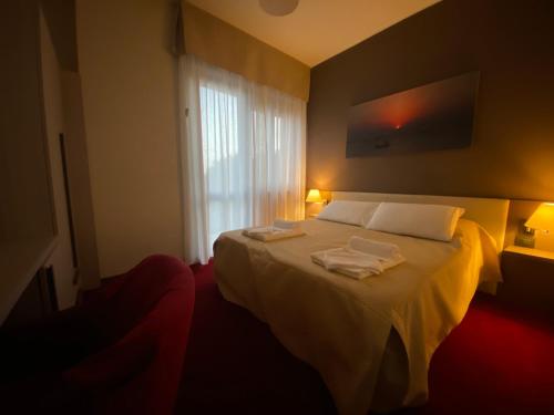 a bedroom with a bed with two towels on it at hotel lido in Viverone