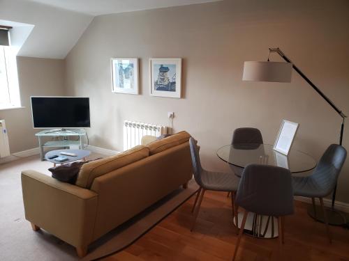 a living room with a couch and a table at Bowness On Windermere, Excellent Apartment For 4 With Parking in Bowness-on-Windermere