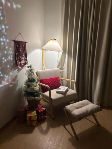 a living room with a chair and a christmas tree at 1.Hôme in Hanoi