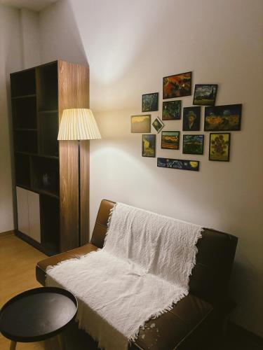 a living room with a couch and some pictures on the wall at 1.Hôme in Hanoi
