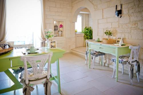 - une cuisine avec des tables et des chaises vertes et blanches dans l'établissement Casa Nonna Stella, à Martina Franca