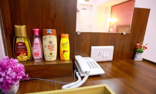 a room with a phone and some bottles on a table at Base9 Family Lounge -Cochin Airport in Nedumbassery