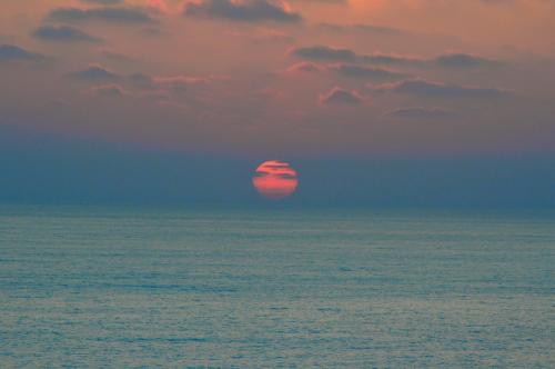 a red ball in the ocean under a cloudy sky at Olymp Luxury House - Ultra Luxury Beachfront Villa with Rooftop Lounge in Paphos