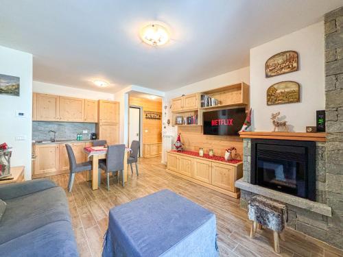 ein Wohnzimmer mit Kamin und ein Esszimmer in der Unterkunft Aprica , Lusso a 300m dalle Piste da Sci, Garage Privato e Deposito Sci Gratuito in Le Bratte