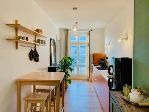 une cuisine avec une table et une salle à manger dans l'établissement les appartements du 10, à Rochefort