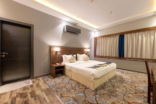 a hotel room with a bed and a walk in shower at Luma Serviced Apartments in Al Madinah
