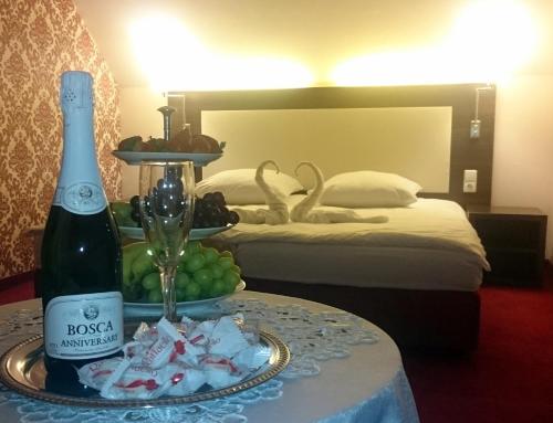 a hotel room with a bottle of wine and a plate of grapes at Pirčių slėnis in Šniūraičiai