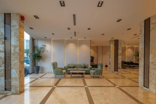 a lobby with a couch and two chairs at Luma Serviced Apartments in Al Madinah
