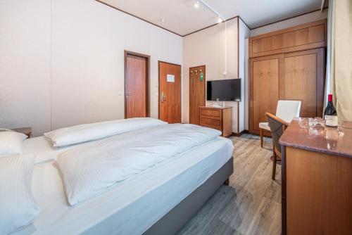 a bedroom with a large white bed and a desk at Hotel Neue Post I self check-in in Innsbruck