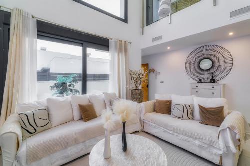 ein Wohnzimmer mit 2 weißen Sofas und einem Tisch in der Unterkunft Villa White Diamond - Piscine - Plage 10 minutes in Daya Vieja