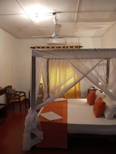 a bed with a canopy in a room at Dishari Tangalle in Tangalle
