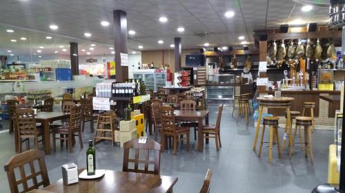 un restaurant avec des tables et des chaises en bois ainsi que de nombreuses tables dans l'établissement Hotel León, à La Palma del Condado