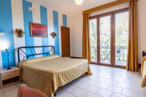 a bedroom with a bed and a large window at Hotel Il Lato Azzurro - Isola di Sant'Erasmo - NO VEHICLES ACCESS in Venice