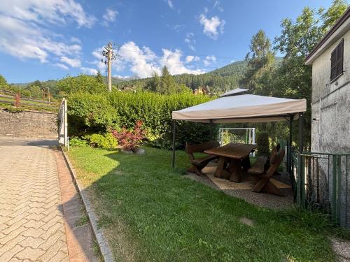 a picnic table under a tent in a yard at Ampio Trilocale sulle Piste della Magnolta, Deposito sci Gratuito in Aprica
