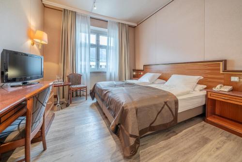a hotel room with a bed and a flat screen tv at Hotel Neue Post I self check-in in Innsbruck