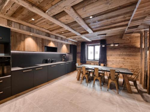 - une cuisine avec une table et des murs en bois dans l'établissement Alpina Lodge - appartement Premium avec Sauna à Val Cenis, à Val Cenis