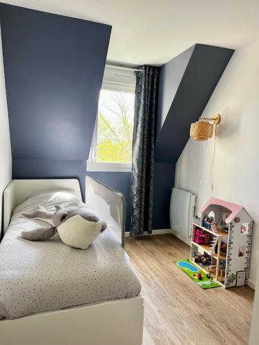 - une chambre dotée d'un lit avec un mur bleu dans l'établissement Charmant Duplex entre Terre et Mer proche Plage avec Balcon, à Cabourg
