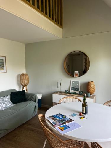 un salon avec une table et un canapé dans l'établissement Charmant Duplex entre Terre et Mer proche Plage avec Balcon, à Cabourg