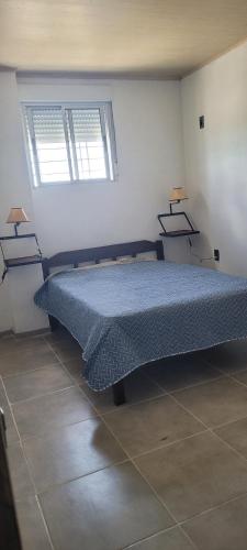 a bedroom with a bed with two lamps on the wall at Apartamento Romian Ián in Paysandú