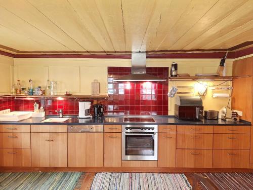 a large kitchen with wooden cabinets and red tiles at Haus Völlegg in Völlegg