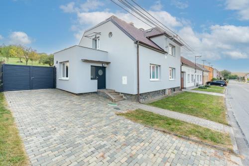 a white house with a fence and a driveway at U Lokajů in Rašovice
