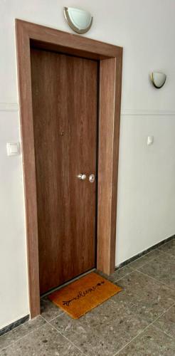 a wooden door in a room with a door mat at Elaion guest house in Athens