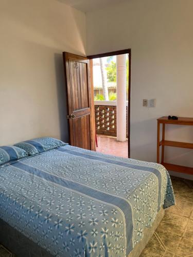 Un dormitorio con una cama con un edredón azul. en Cabañas Edda, en Puerto Escondido