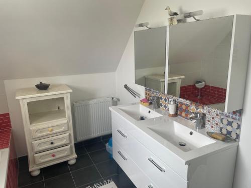 a bathroom with a white sink and a mirror at Hébergement Golfe du Morbihan - Ty Baden in Baden