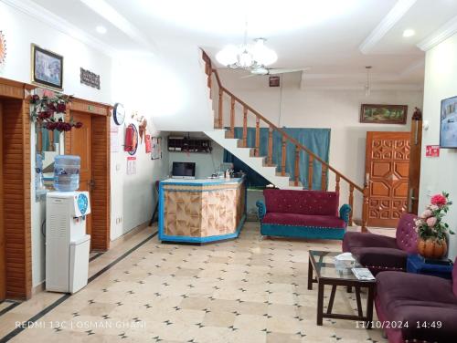 Una sala de estar con una escalera y un sofá. en Orion International Guest House, en Islamabad
