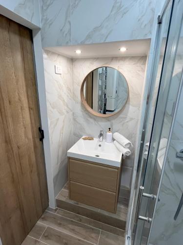 une salle de bain avec un lavabo et un miroir dans l'établissement Renovated Seaside Studio in the Heart of Menton, à Menton