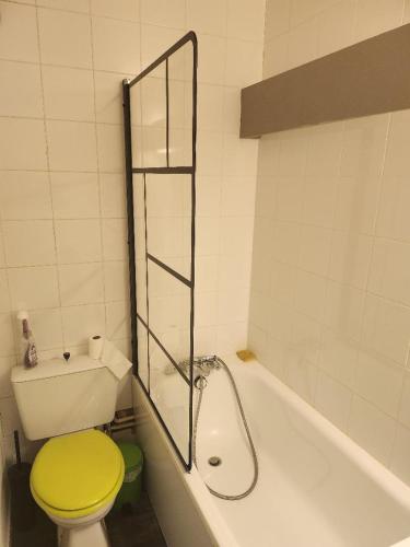 La salle de bains est pourvue de toilettes jaunes et d'une baignoire. dans l'établissement La Mongie appartement L42 au pieds du Tourmalet, à Bagnères-de-Bigorre