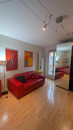 a living room with a red couch and a mirror at A casa di Giò e Lorenzo- Appartamento via Guidelli in Reggio Emilia