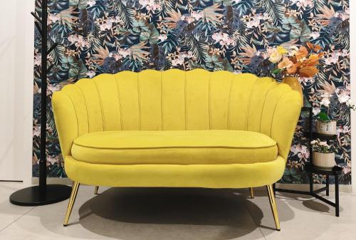 a yellow chair in front of a wall with flowers at Le Popolari - Appartamento in Bitonto