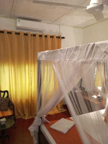 a room with a bed with a curtain at Dishari Tangalle in Tangalle