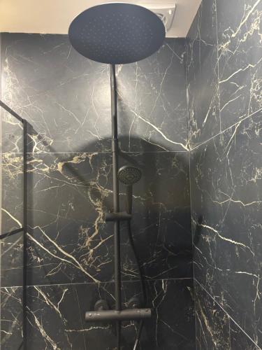 - un tabouret dans la salle de bains aux murs en marbre noir dans l'établissement Appartement cosy sur Nancy, à Nancy