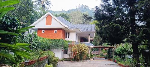 a house with a fence in front of it at Nadackal Nature County in Munnar