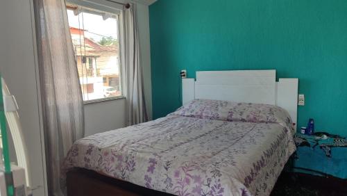 un dormitorio con una cama y una ventana en Casita da barra, en Búzios