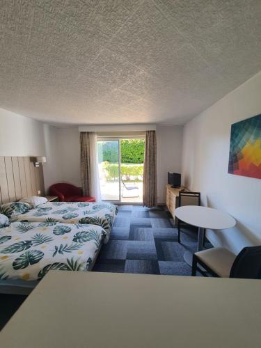 a hotel room with two beds and a table at Studio Golf&Plage Chiberta in Anglet