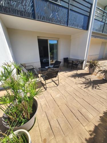 a patio with chairs and plants on a building at Studio Golf&Plage Chiberta in Anglet