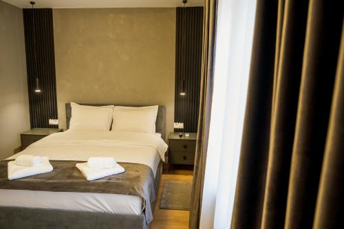 a bedroom with a bed with two towels on it at Nova Studio Apartments in Reghin