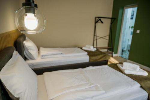 two beds in a room with a mirror and a lamp at Nova Studio Apartments in Reghin