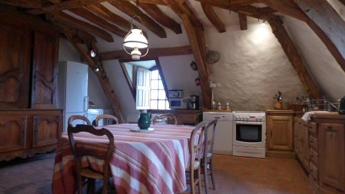 une cuisine avec une table avec une nappe rouge et blanche dans l'établissement Gite du Manoir du Plessis- 3km de Villandry, à Savonnières