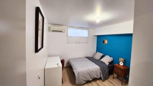 - une petite chambre avec un lit et un mur bleu dans l'établissement Le refuge d'Albi - Charmant T3 lumineux et tout équipé, à Albi
