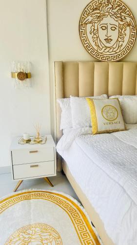 a bedroom with a bed with a gold headboard and a rug at Fela in Versace House in Gqeberha