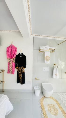 a white bathroom with a toilet in a room at Fela in Versace House in Gqeberha