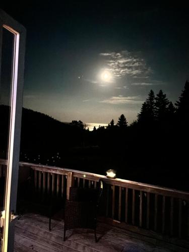 a view of the moon from a deck at night at Ingonish Loft in Ingonish