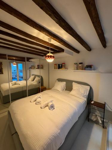 une chambre avec un grand lit avec des draps blancs dans l'établissement Charmant appart Montmartre, à Paris