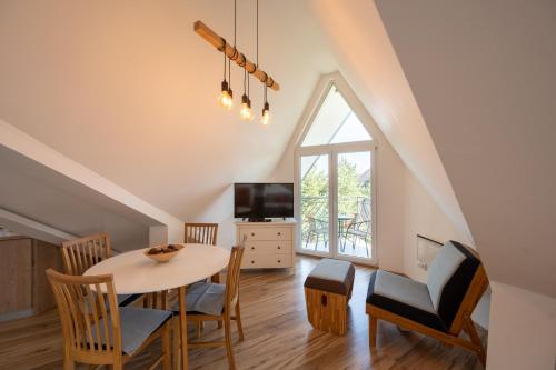 a dining room with a table and chairs and a tv at Apartman Senka 2 in Divčibare