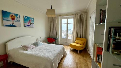 - une chambre avec un lit et une chaise jaune dans l'établissement Amazing view in Montmartre, 2 min from Sacre-Coeur, à Paris