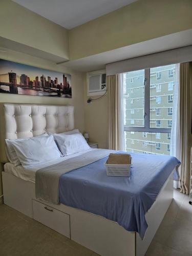 Un dormitorio con una cama grande con una ventana grande. en 17th of Sky View Home- Cebu IT Park, en Cebú